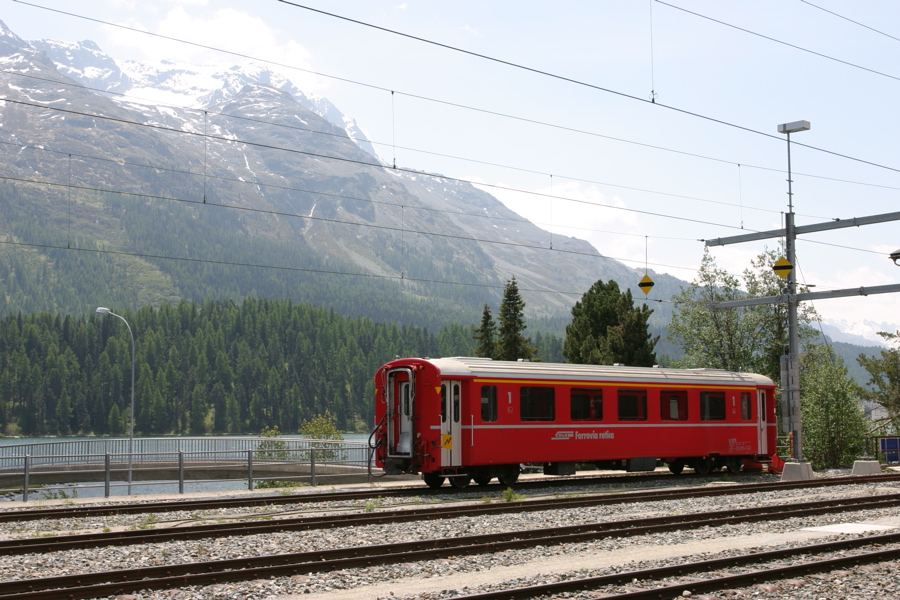 Ein typischer RhB-Personenwaggon vor der Bergkulisse von St. Moritz